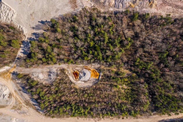 An aerial view of a mining site undergoing land reclamation and reforestation efforts, showcasing a mining company's commitment to environmental sustainability and responsible resource management.