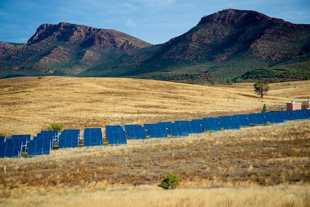 A solar panel field in the Peruvian desert, with mountains in the distance under a clear blue sky. The image emphasizes the potential for renewable energy projects in Peru.
