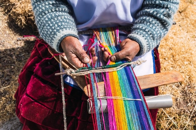 Close-up image of a Peruvian weaver expertly using a traditional backstrap loom to create a colorful textile, highlighting the intricate details of the weaving process.