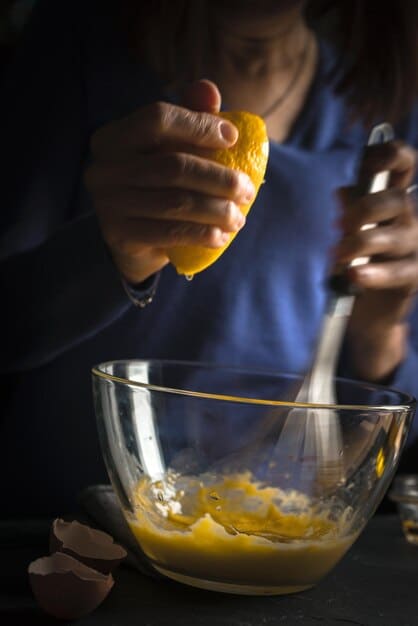 Close-up shot of a bartender in Peru meticulously preparing a Pisco Sour, focusing on the frothy egg white and the bitters being delicately dropped on top.