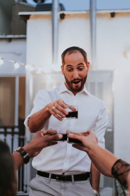 A Peruvian-American professional confidently participating in a networking event, exchanging business cards and engaging in conversation. The image conveys professionalism, cultural pride, and the importance of building connections.