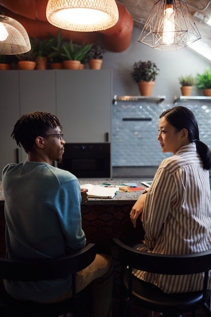 A diverse group of Peruvian-American entrepreneurs participating in a workshop, led by a seasoned business mentor. The scene shows active listening, note-taking, and collaborative problem-solving.