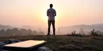 Person enjoying sunrise, symbolizing digital well-being and screen time reduction